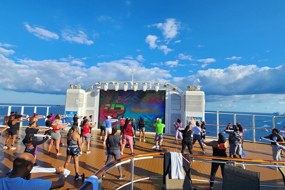 Cours de fitness sur le pont d'un bateau de croisière avec vue sur l'océan et le ciel bleu